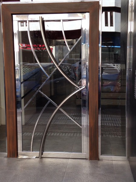 Puerta de portal con estructura inoxidable y tiradores curvos